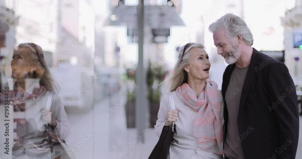 Senior Adult couple on holiday looking at shop window Senior Adult couple on holiday looking at shop window