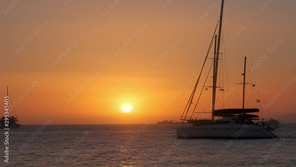 Sunset in Mykonos, Greece, with cruise ships and yachts in the harbor Sunset in Mykonos, Greece, with cruise ships and yachts in the harbor