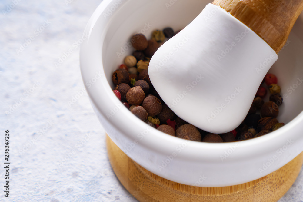 pounder with mix of different spices peppers on white background.