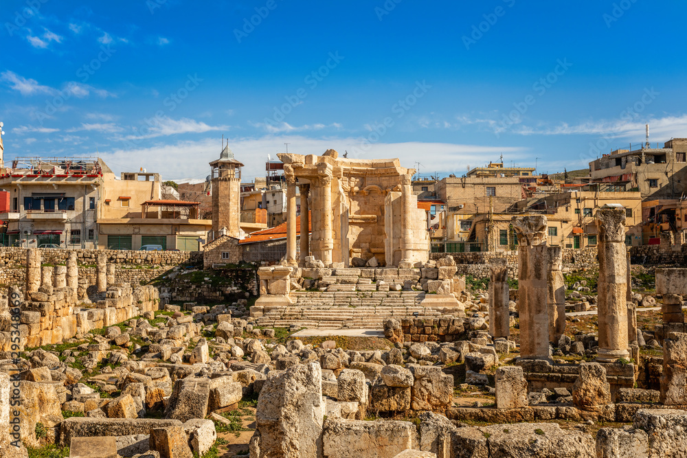 The ruins and only fragment of Venus temple left with modern houses and blue sky in the background, Beqaa Valley, Baalbeck, Lebanon