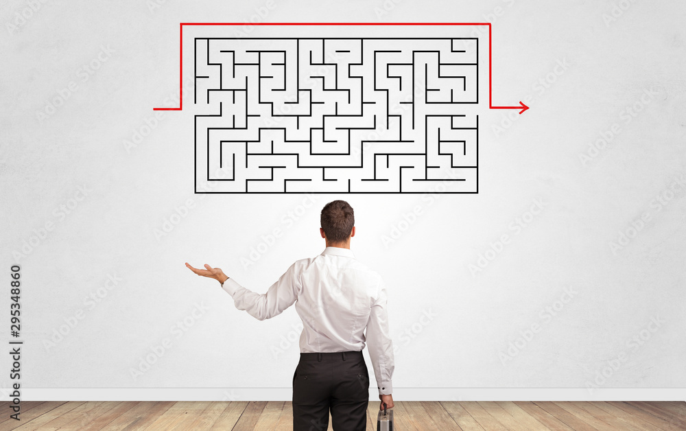 Businessman in doubt looking to a maze and searching the way out Businessman in doubt looking to a maze and searching the way out
