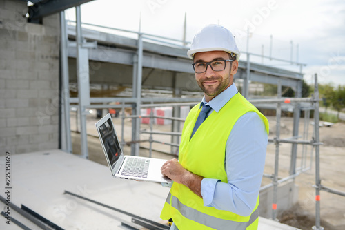 portrait of handsome foreman construction worker on a industrial building industry construction site