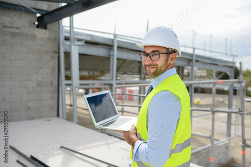 portrait of handsome foreman construction worker on a industrial building industry construction site