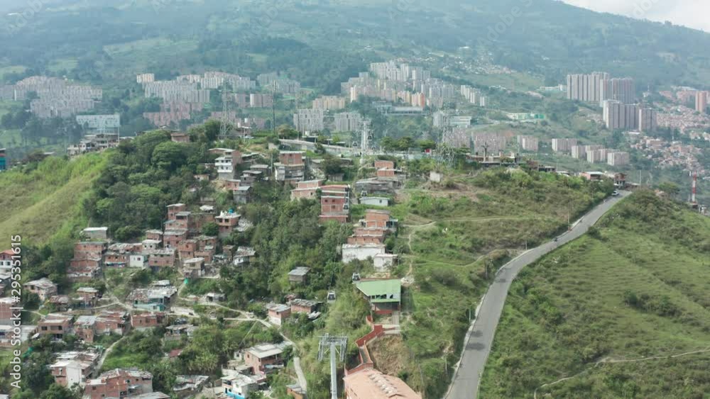 An aerial shot from moving cable cars to a bridge over a road with moving vehicles. 