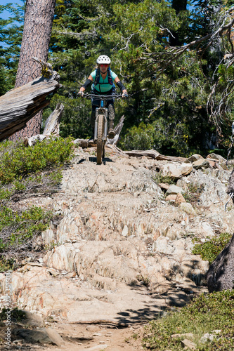 female mountain biker on rock garden