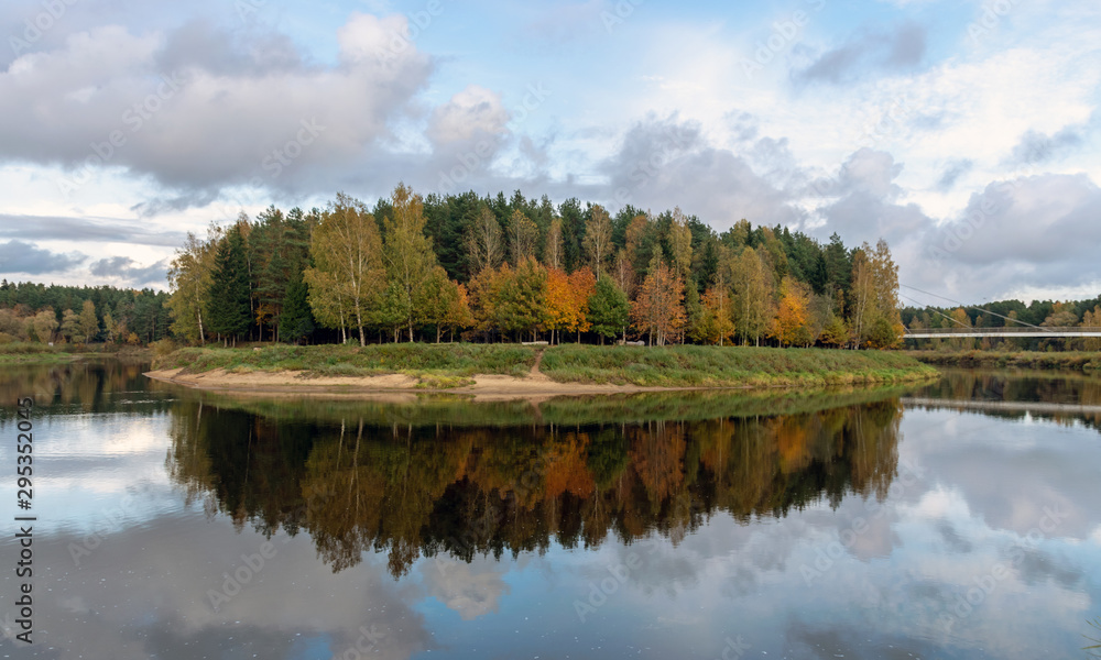 Fototapeta premium autumn landscape with river, calm water, beautiful colorful trees, water reflections, river Gauja, Valmiera, Latvia