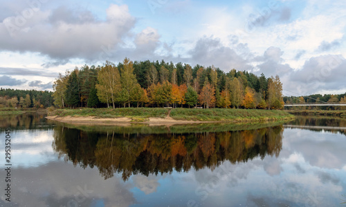autumn landscape with river, calm water, beautiful colorful trees, water reflections, river Gauja, Valmiera, Latvia