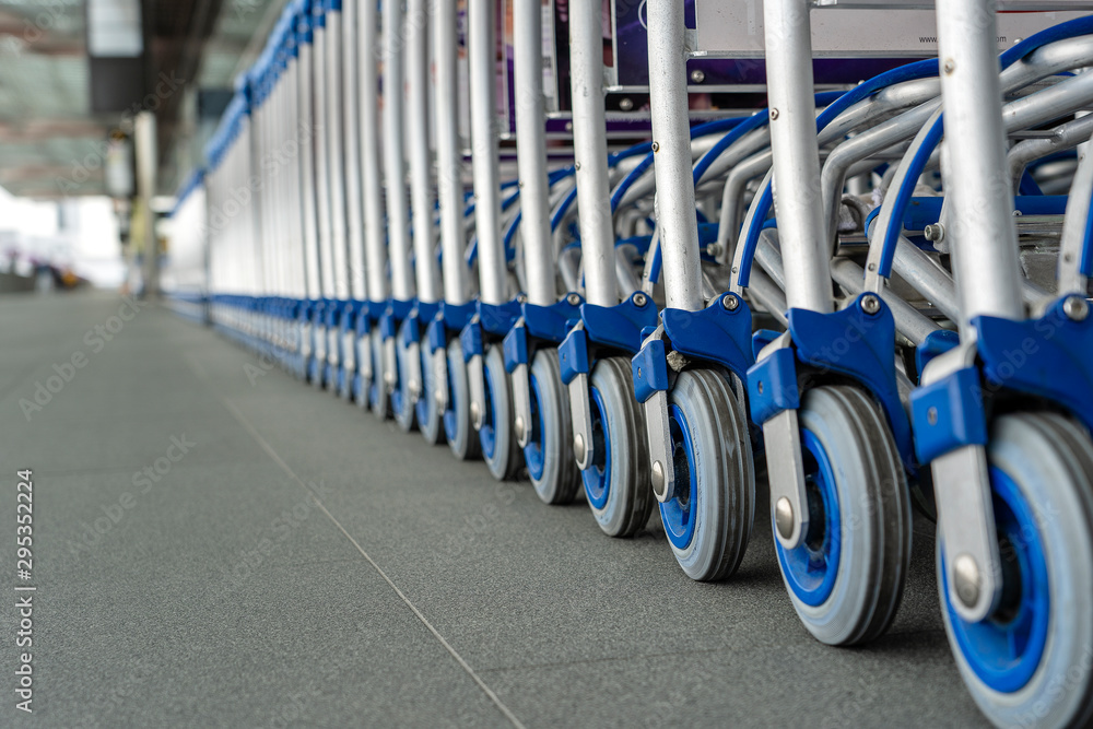 Trolleys luggage in a row in modern airport. Close up of luggage carts