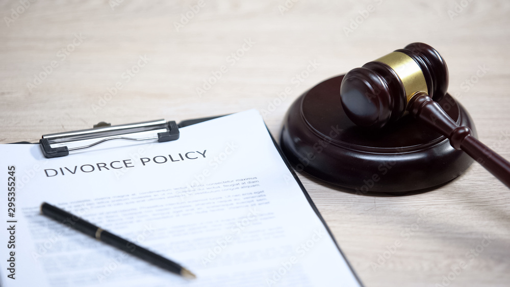 Divorce policy document on table, gavel lying on sound block, family law