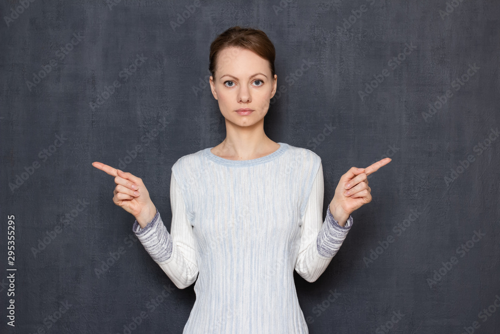 Portrait of serious focused girl pointing to different sides Portrait of serious focused girl pointing to different sides
