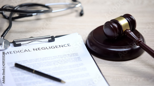 Foto Medical negligence and stethoscope on table, gavel lying on sound block