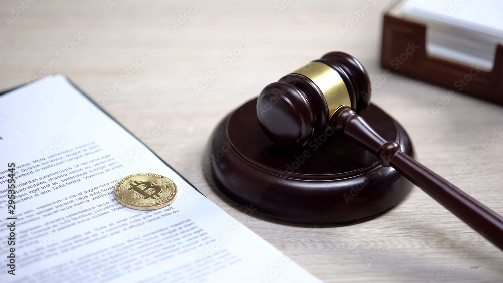 Bitcoin on document, gavel lying on sound block, digital currency regulations Bitcoin on document, gavel lying on sound block, digital currency regulations