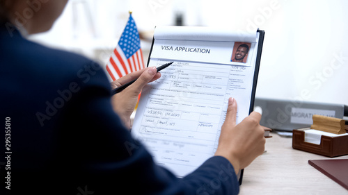 Foto Consul worker checking visa application office, american flag, migration concept