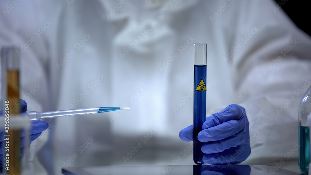 Scientist of toxic lab examining sample of blue ionizing radiation liquid danger Scientist of toxic lab examining sample of blue ionizing radiation liquid danger