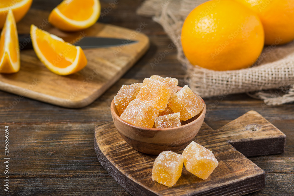 Orange marmalade. Sprinkle the marmalade with sugar in a wooden bowl on a wooden table Orange marmalade. Sprinkle the marmalade with sugar in a wooden bowl on a wooden table