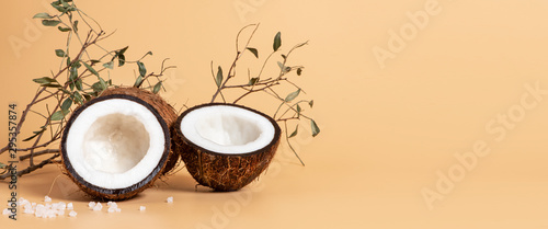 Sliced coconut on a soft orange background, free space for text, banner. Skincare concept, copy space.