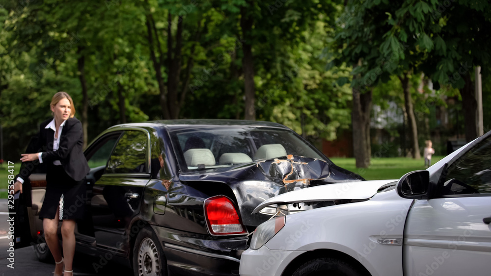 Shocked female driver getting out car looking at wrecked cars on road, safety Shocked female driver getting out car looking at wrecked cars on road, safety