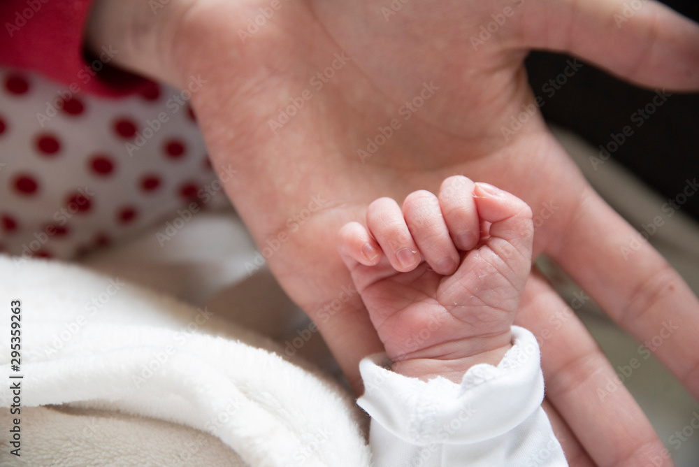 Hand in hand with mother son son in an act of tenderness. The newborn gets in touch with his mother through body contact.