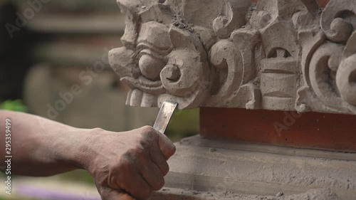 Stone carving master is making statue of a Balinese deity. 