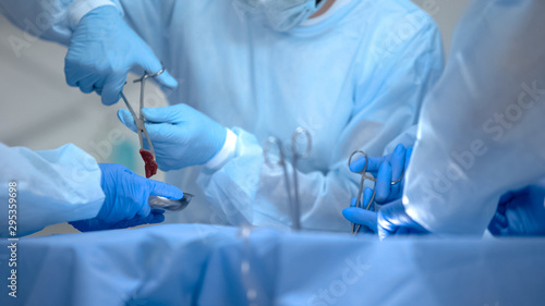 Surgeon removing unhealthy part of body, excision of tumor operation, hospital photo