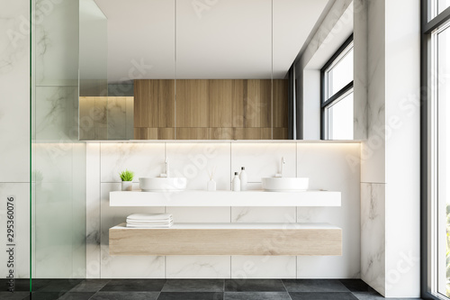 Double sink in white marble bathroom interior