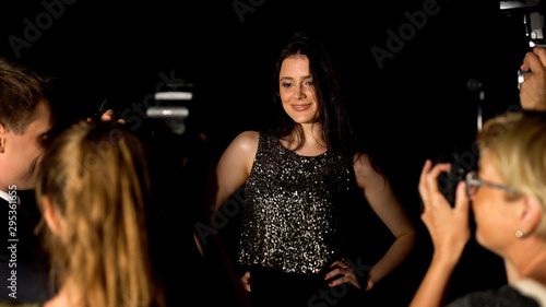 Popular glamorous female singer posing for paparazzi cameras on luxury event