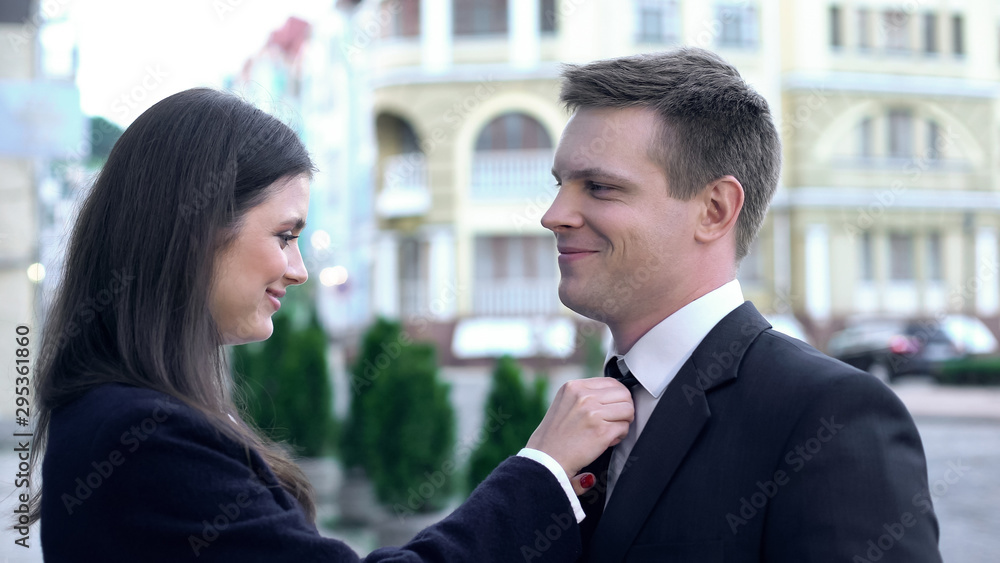 Caring wife of politician straightening husbands tie, perfect morning, relations Caring wife of politician straightening husbands tie, perfect morning, relations