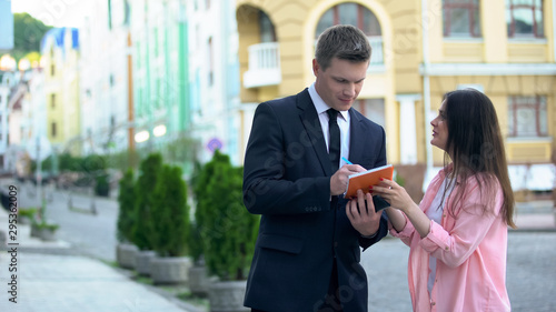 фотографія Rich businessman signing autograph in notebook of young excited female fan