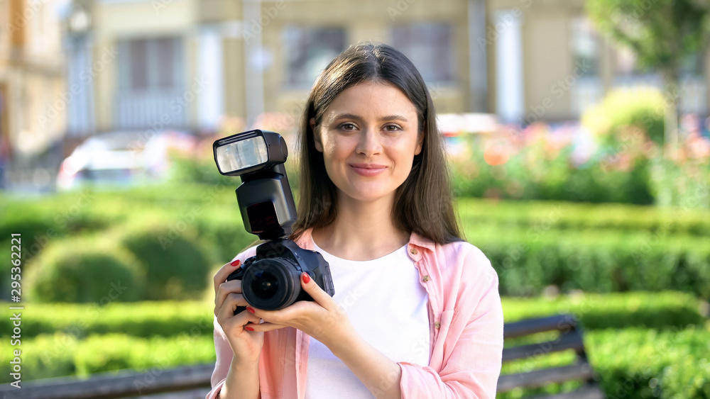 Smiling woman holding camera, tips for professional photographers, shooting