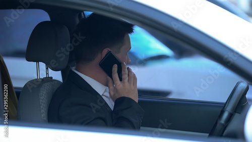 Obraz na plátně Secret agent spying from car, talking phone with partner, discussing information