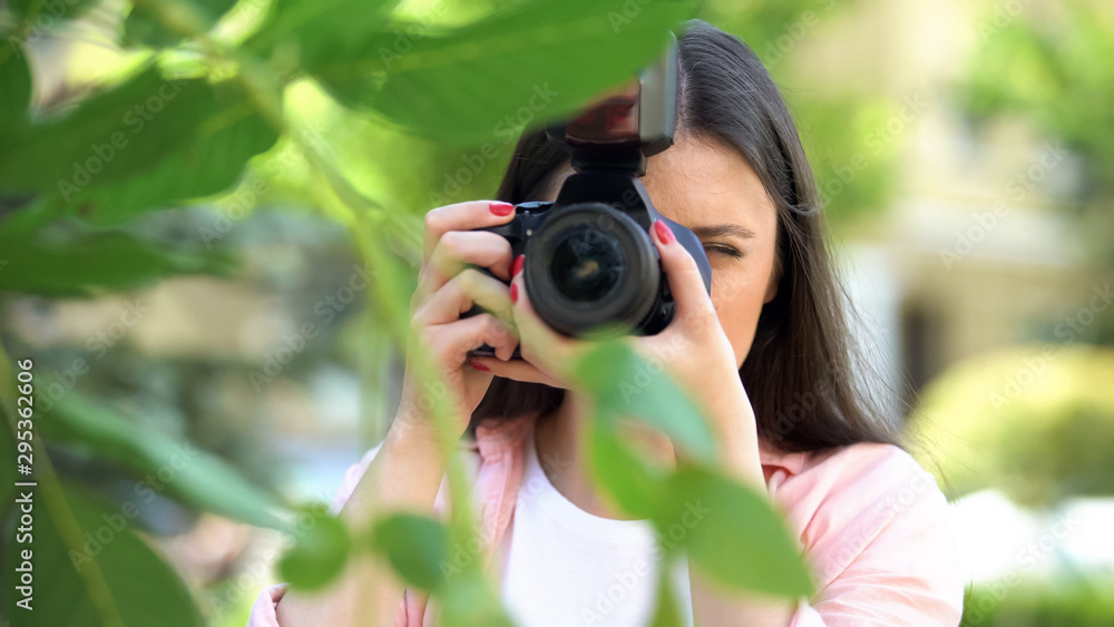Female photographer with professional camera making photos at city park Female photographer with professional camera making photos at city park