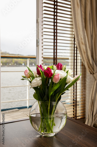 Bouquet of flowers in a vase on a coffee table in the interior of the room