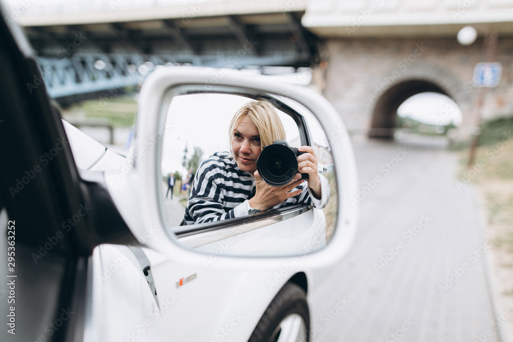 Photographer woman take phto shoot from car outdoors