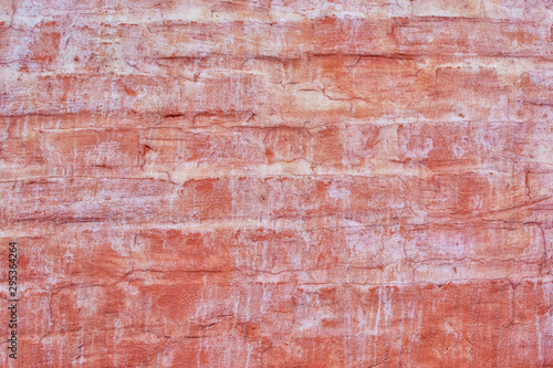 Brick wall painted with dark orange paint. Old paint stains and smudges. Empty background for layouts and sites.