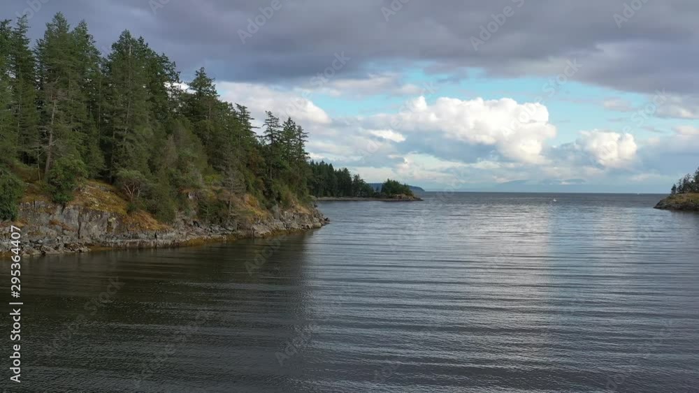Aerial view over inlet, ocean and island with boat and mountains in beautiful British Columbia. Canada. 4K. Aerial view over inlet, ocean and island with boat and mountains in beautiful British Columbia. Canada. 4K.