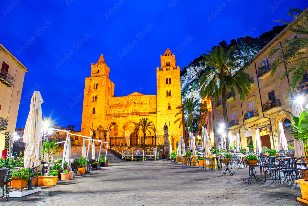 Cefalu, Sicily, Italy: Night view of the town square with The Cathedral or Basilica of Cefalu, a Roman Catholic church built in the Norman style