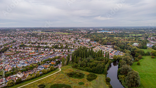 Fototapeta Naklejka Na Ścianę i Meble -  An aerial view of an urban area along a park under a grey sky and white clouds