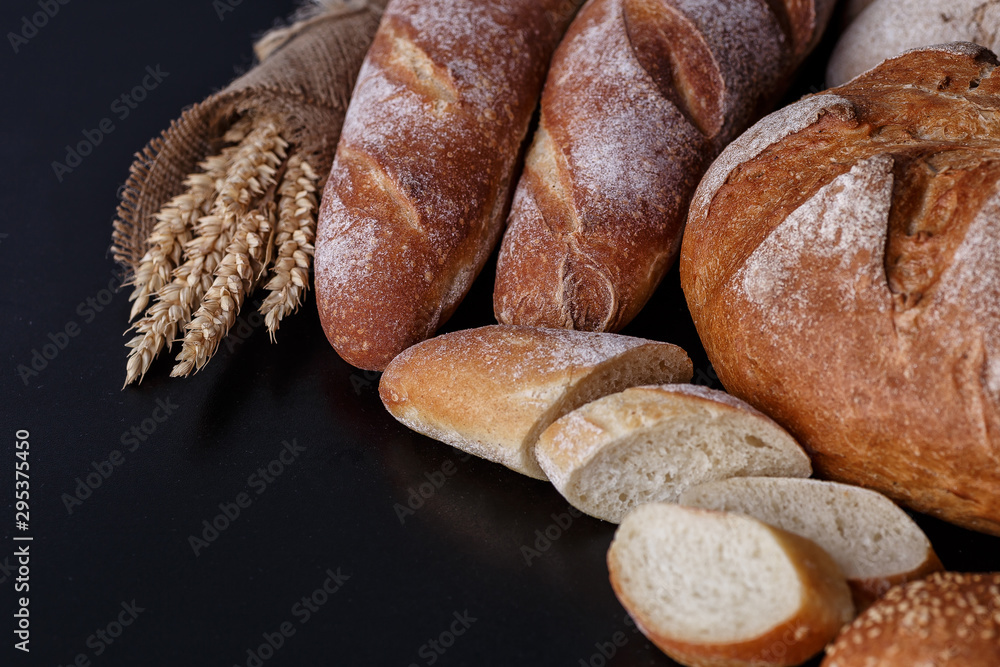 Bakery - gold rustic crusty loaves of bread and buns on black chalkboard background.