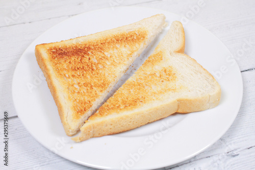Sliced toast bread on plate on white wood table