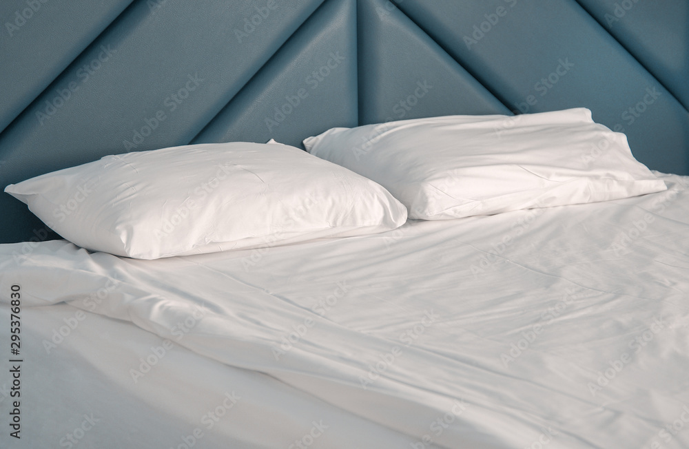 Bed white pillows on white bed in bedroom. Hotel service. Bed white pillows on white bed in bedroom. Hotel service.