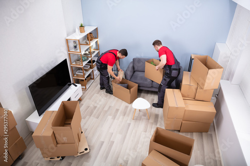 Men Loading The Cardboard Boxes During Moving photo