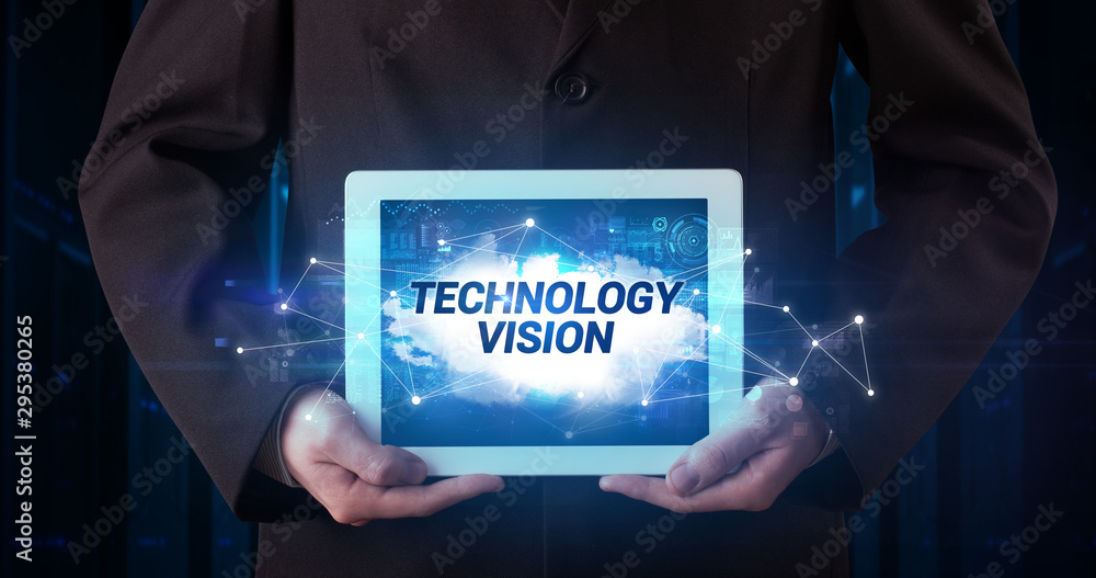 Young business person working on tablet and shows the inscription: TECHNOLOGY VISION Young business person working on tablet and shows the inscription: TECHNOLOGY VISION
