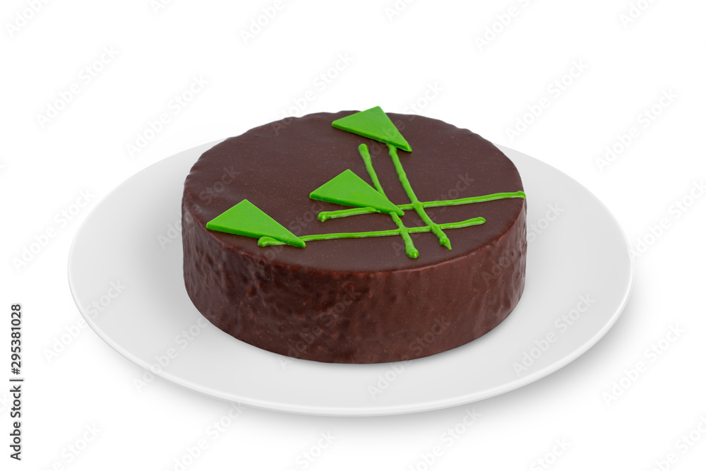 A round biscuit cake with cream lies on a white plate on a white background. A round biscuit cake with cream lies on a white plate on a white background.