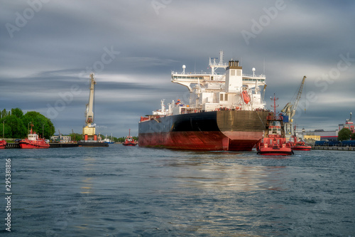 The Port of Gdansk, Poland, tugs enter the port of a large merchant ship