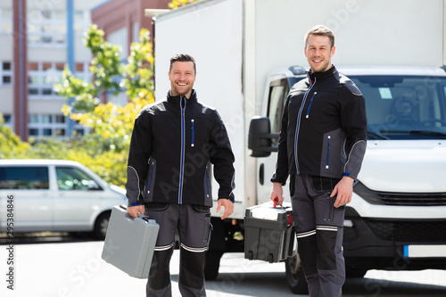 Foto Portrait Of Two Male Electrician Carrying Tool Boxes