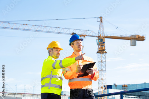 Two Male Architects Working On Construction Site