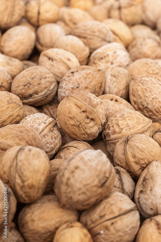 Natural walnut background with blurred edges frame. Natural food in-shell nuts
