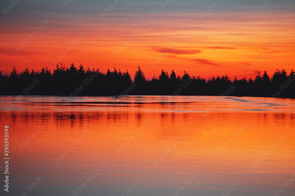 Beautiful sunset color tones in the mountains. Lake with pine tree silhouette and water reflections. Calm idyllic and peaceful place to enjoy mountains. Wurmberg, Braunlage Harz National Park - obrazy, fototapety, plakaty 