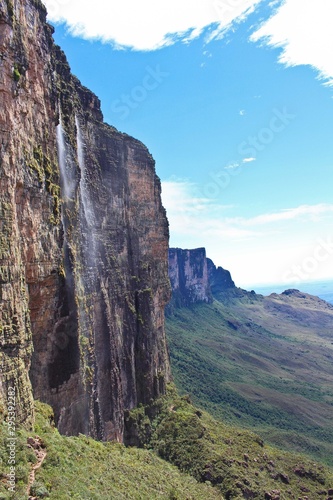 Sheer cliffs of Mount Roraima - landscape with blue sky and waterfall. View on the Gran Sabana and Mount Roraima. Venezuela