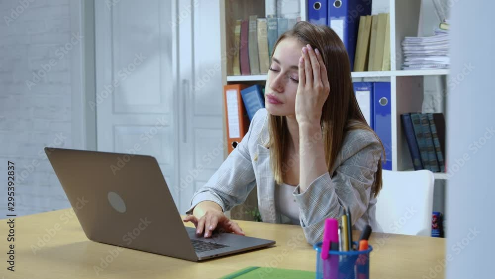 Portrait of tired young businesswoman getting bored of dull work in the office. Unmotivated female worker is exhausted of working by computer. Portrait of tired young businesswoman getting bored of dull work in the office. Unmotivated female worker is exhausted of working by computer.